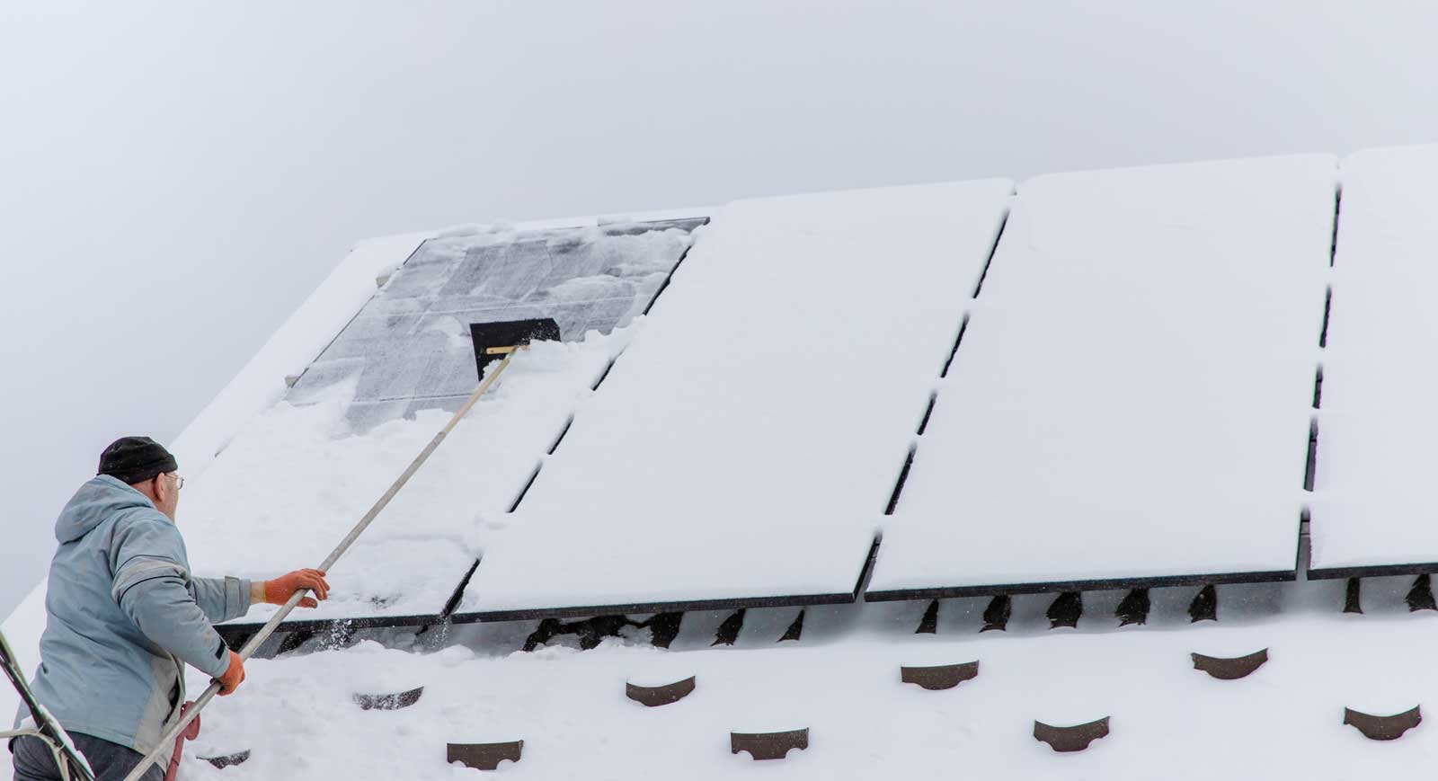 Clear snow from solar panels. Selective focus.